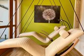 Im Familienhotel Ramsi laden stilvolle Schwebeliegen in einem gemütlichen Ruheraum mit warmem Licht und Naturakzenten zum Entspannen ein