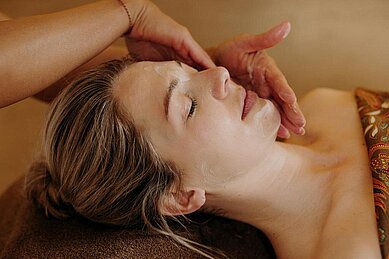 Eine Masseurin im Hotel Habachklause gibt einem Gast eine Gischts-Massage. 