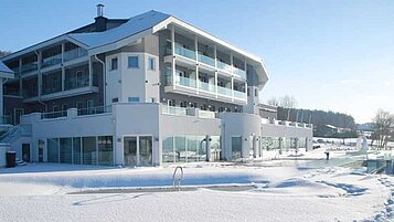 Das Familienhotel Aigo in Oberösterreich im Winter bei herrlichem Sonnenschein.