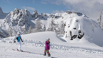 Familie im Winter beim Skifahren und Snowboarden. Das Skigebiet befindet sich in Nassberg.