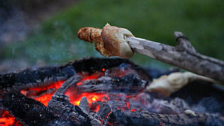 Stockbrot über der Feuerglut machen