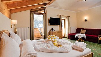 Familiensuite mit Doppelbett und Couch im Adler Familien- & Wohlfühlhotel in Tirol.