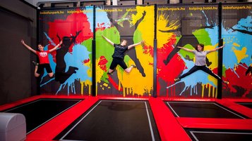 Drei Kinde springen Trampolin im Bobo Fun Park im Kolping Family Resort in Ungarn.