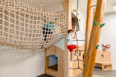 Kind klettert und spielt im Indoor Spielbereich im Familienhotel Amiamo im Salzburger Land.