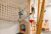 Kind klettert und spielt im Indoor Spielbereich im Familienhotel Amiamo im Salzburger Land.