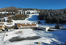 Winterliche Luftaufnahme des Familienhotels Petschnighof in Kärnten.