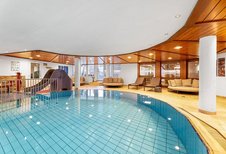 Hallenbad mit großzügigem Pool, Holzdecke und Ruheliegen im Wellnessbereich des Hotel Engel im Schwarzwald