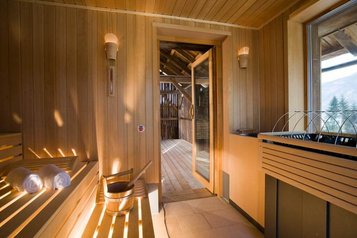 Im Familienhotel Ramsi in Kärnten lädt eine gemütliche Sauna mit Holzverkleidung und Blick ins Freie zum Entspannen und Wohlfühlen ein