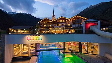 Außenansicht des Familienhotels Huber in Südtirol bei Abenddämmerung.