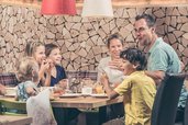Familienhotel Mia Alpina in Tirol mit Familie beim Essen im gemütlichen Restaurant.