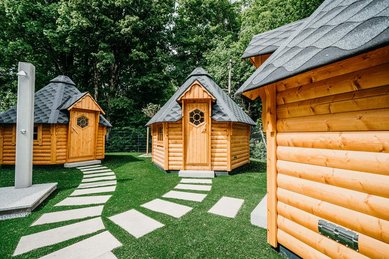 Hütten im Gartenbereich vom Familienhotel Friedrichshof mit urigem Holzdesign und viel Platz zum Spielen.