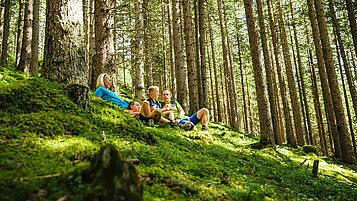 Wandern im Salzburger Land: Familie macht im Wald im Raurisertal eine kleine Pause.