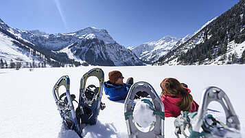 Beine hochlegen muss bei einer anstrengenden Tour auch mal sein. Schneeschuhwanderungen im Winter im Schnee sind für alle etwas die von der Landschaft buchstäblich umgehauen werden wollen.