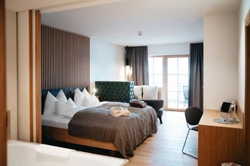 Große Familiensuite mit einem Schlafzimmer und einem Wohnbereich im Familienhotel Post Family Resort im Salzburger Land.