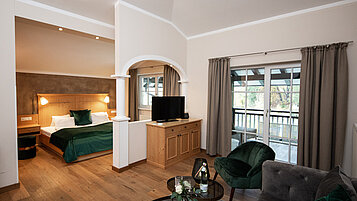 Große Familiensuite mit einem Schlafzimmer und einem Wohnbereich im Familienhotel Post Family Resort im Salzburger Land.