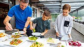 Vater und zwei Jungs bedienen sich am bunten Salatbuffet des Familienhotels Alpengasthof Hochegger.