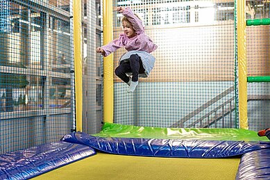 Mädchen springt auf dem Trampolin im Abenteuerland des Familienhotels Sonnenpark im Sauerland