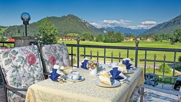 Blick auf einen gedeckten Tisch auf der Terrasse des Familienhotels Bavaria im Allgäu mit Blick auf die Berge