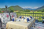 Blick auf einen gedeckten Tisch auf der Terrasse des Familienhotels Bavaria im Allgäu mit Blick auf die Berge