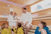 Eine Familie genießt gemeinsam entspannte Wohlfühlmomente in der Familiensauna im Familienhotel Tirolerhof