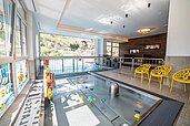 Das Babybecken mit vielen Spielzeugen und Ausblick auf den Infinitypool im Kinderhotel Stefan in Pitztal.