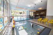 Das Babybecken mit vielen Spielzeugen und Ausblick auf den Infinitypool im Kinderhotel Stefan in Pitztal.