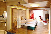 Schönes Doppelzimmer Superior mit mit Blick ins Badezimmer durch Glastüren im Familienhotel Das Kaltschmid in Seefeld in Tirol.