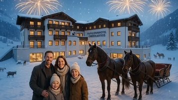 Familie vor dem festlich beleuchteten Familienhotel Oberkarteis mit Pferdeschlitten und Feuerwerk im verschneiten Winterpanorama.