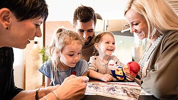 Familie mit zwei Kindern freut sich bei Ankunft im Familienhotel auf den gemeinsamen Urlaub