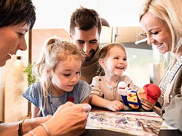 Familie mit zwei Kindern freut sich bei Ankunft im Familienhotel auf den gemeinsamen Urlaub
