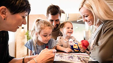 Familie mit zwei Kindern freut sich bei Ankunft im Familienhotel auf den gemeinsamen Urlaub