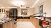 Moderner Buffetbereich im Familienhotel Oberkarteis mit stilvoller Beleuchtung, großzügiger Theke und frischem Frühstücksangebot.