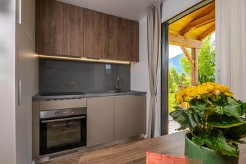 Voll ausgestattete Küche im Tiny House des Familienhotels Ramsi mit Blick auf die Terrasse und die Natur
