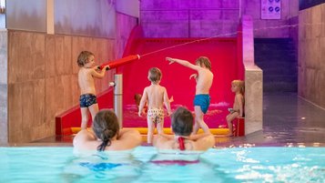 Kinder planschen und toben fröhlich im Wasserspielbereich im Landhaus zur Ohe
