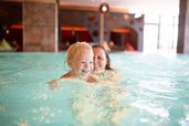 Mutter und Sohn schwimmen entspannt im Hallenbad des Familienhotels Landhaus zur Ohe