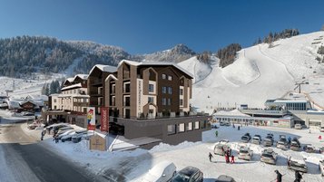 Visualisierung des Familienhotels Zauchenseehof im Winter mit direkter Lage an der Skipiste und Blick auf die Talstation der Zauchenseebahn.
