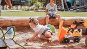 Kind spielt im Sandkasten auf dem Outdoor-Spielplatz des Familienhotels Huber in Südtirol