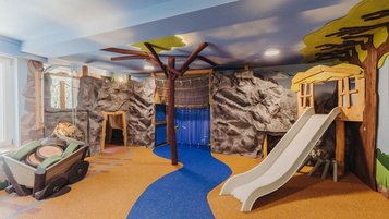 Kreativ gestalteter Indoor-Spielbereich im Familienhotel Habachklause Salzburger Land mit Rutschen und Kletterlandschaft.