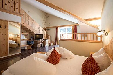 Schlafbereich in der Familiensuite mit einem Doppelbett im Familienhotel Alphotel Tyrol Wellness & Family Resort in Südtirol.