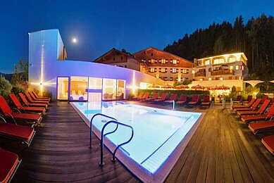 Beleuchteter Außenpool des Familienhotels Amiamo im Salzburger Land