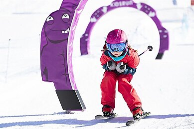 Kkleines Kind in der Skischule fährt die Skipiste im Familienhotel Wellness- & Familienhotel Egger in Saalbach Hinterglemm hinunter.