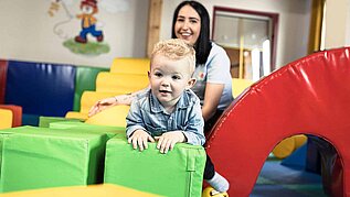 Ein Baby spielt unter Aufsicht im Happy Club im Familienhotel