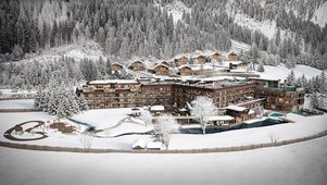 Winterliche Visualisierung des Familienhotels Alpura Retreat in Südtirol mit verschneiter Bergkulisse, Chalets und Außenanlagen.