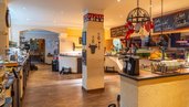 Offene Küche im Familienhotel Borchards Rookhus an der Mecklenburgischen Seenplatte mit frischen Kräutern und Backwaren, die eine einladende Atmosphäre für kulinarische Erlebnisse schafft.