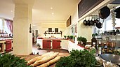 Offene Küche im Familienhotel Borchards Rookhus an der Mecklenburgischen Seenplatte mit frischen Kräutern und Backwaren, die eine einladende Atmosphäre für kulinarische Erlebnisse schafft.