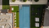 Draufsicht auf den Outdoor-Pool und die Liegewiese des Familienhotels Scherer mit stilvoller Gartenanlage.