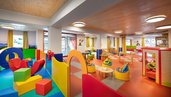 Farbenfroher Indoor-Spielbereich im Zauchenseehof mit Kletterelementen, gemütlichen Sitzsäcken und vielen Spielmöglichkeiten für Kinder