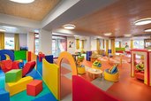 Farbenfroher Indoor-Spielbereich im Zauchenseehof mit Kletterelementen, gemütlichen Sitzsäcken und vielen Spielmöglichkeiten für Kinder
