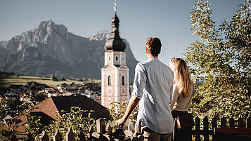 Diese Stadt in Südtirol beeindruckt mit ihrem Ausblick auf eine Kirche und die Berge. Perfekter Ausflugstipp für die Familie im Sommer.