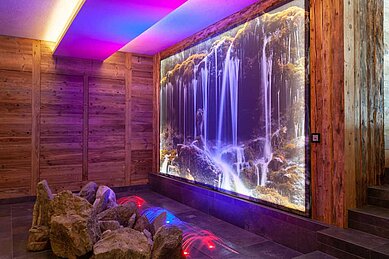 Wellnessbereich mit Wasserfall-Animation im Familienhotel Alphotel Tyrol Wellness & Family Resort in Südtirol.